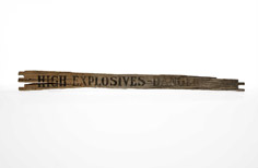Pieces of wood with High-Explosives Danger stenciled on it.