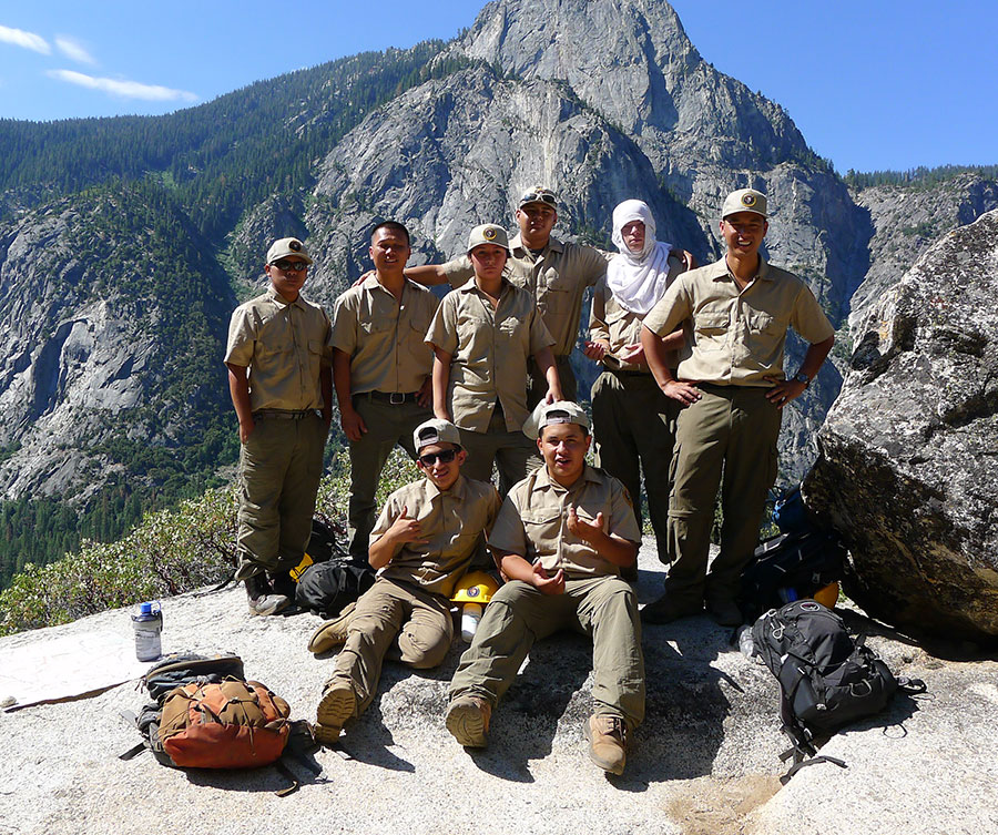 Young men in uniform pose proudly in the wilderness