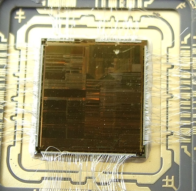 Closeup of square semiconductor and exposed circuitry.