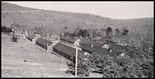 Aerial view of the Pinnacles campsite with 3 rows of long, dark colored buildings with pointed roofs.