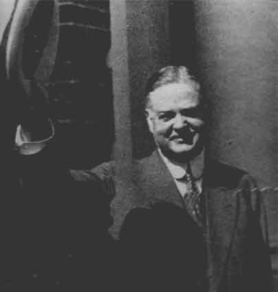 President Hoover waves his hat to the camera.