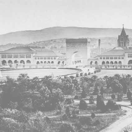 View of Stanford University buildings, including a large arch, with mountains in the background.