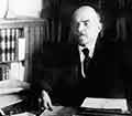 Vladimir Lenin sitting at a desk.