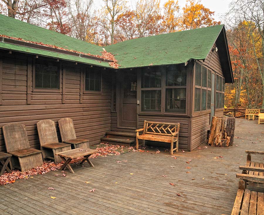 Modern-day photo showing green roof and brown siding and porch.