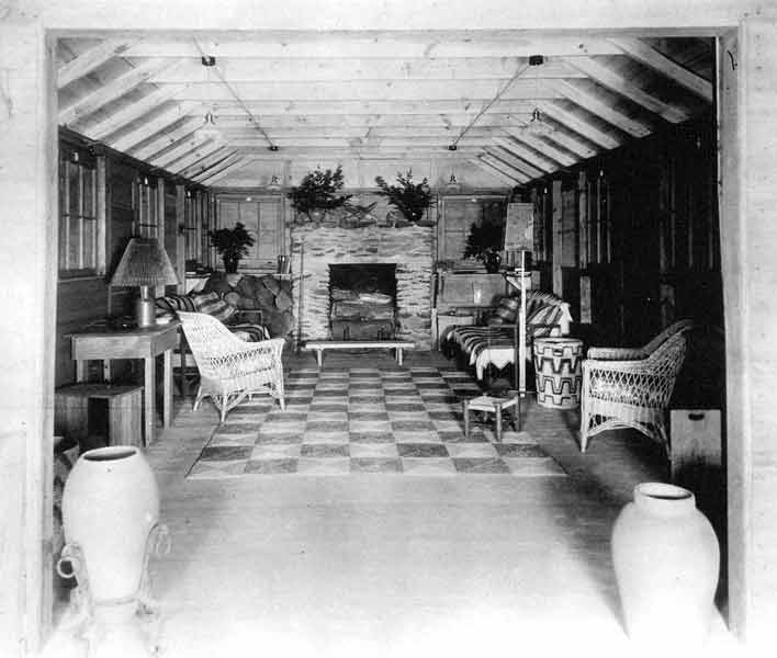 Inside the Town Hall building, with fireplace, wicker furniture, and checkerboard style floor.