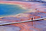 Two people observe the many colors of Grand Prismatic Spring