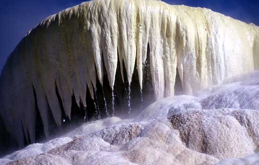 water drips from icicle like formations of travertine