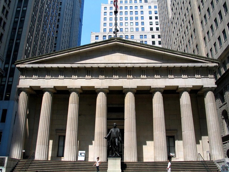 The Wall Street facing steps of Federal Hall with a statue of George Washington.
