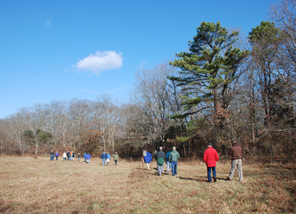 A group of hikers in an open field in autumn