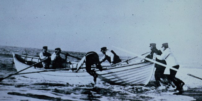 U.S. Life Saving Service crewmen launch a surfboat.