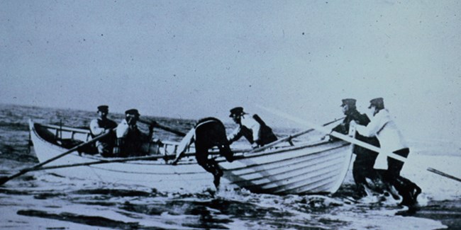 U.S. Life Saving Service crewmen launch a surfboat.