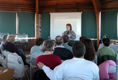 Park ranger presents slide program to group of volunteers.