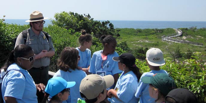 A park ranger talks to a group of students atop a platform in the Sunken Forest.