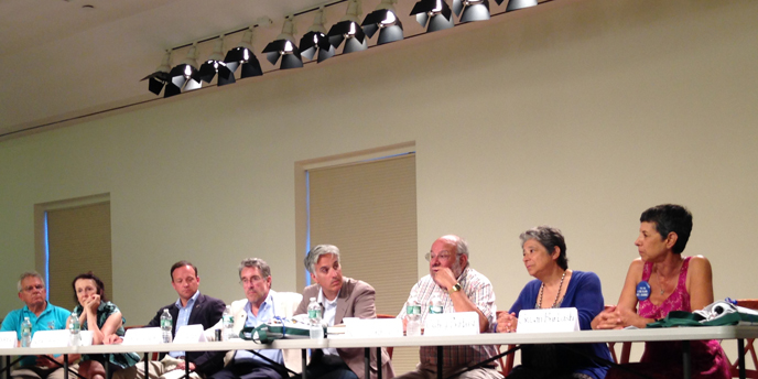 Panelists line a table on stage for a panel discussion on the past 50 years at Fire Island