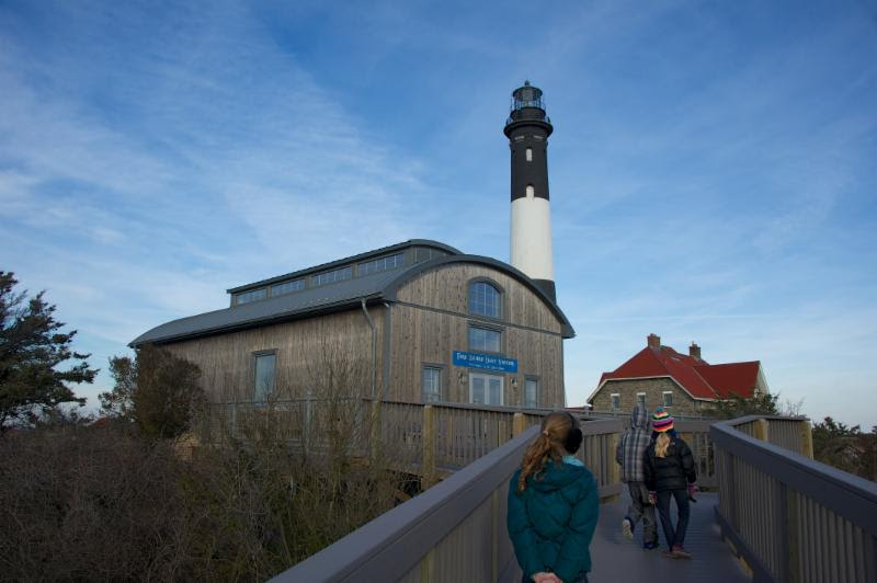 Visitors walk in front of the lighthouse at Fire Island National Seashore.