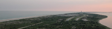 View of Robert Moses State Park's water tower in distance against pink sunset.