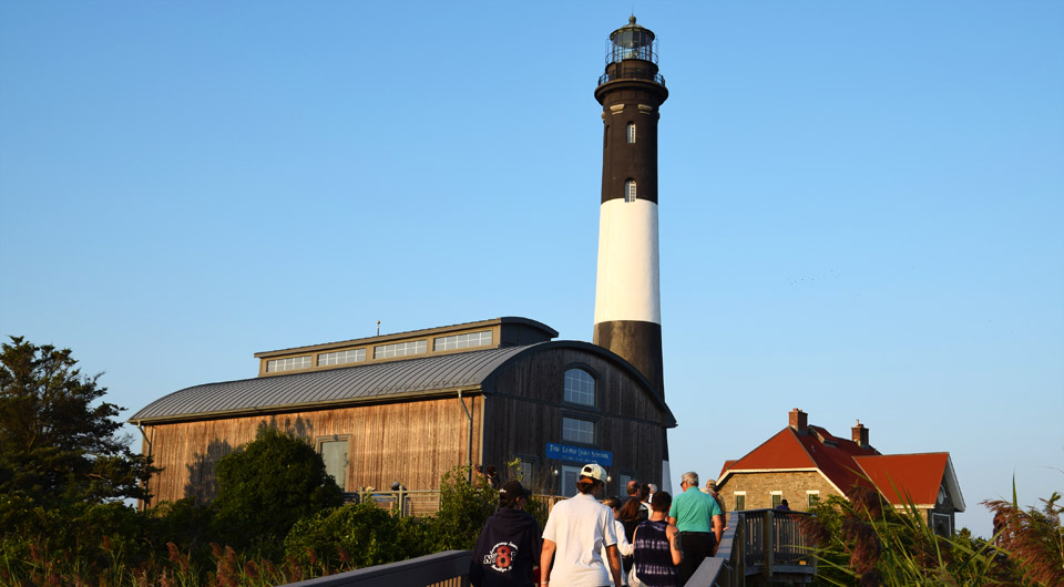 People walking on boardwalk toward Fire Island Lighthouse. People walking on boardwalk toward Fire Island Lighthouse.
