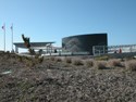 Curved memorial structure is visible beyond dune. 