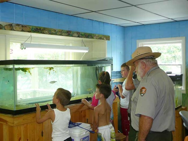 Children explore the fish tank at Sailors Haven Visitor Center. Children explore the fish tank at Sailors Haven Visitor Center.