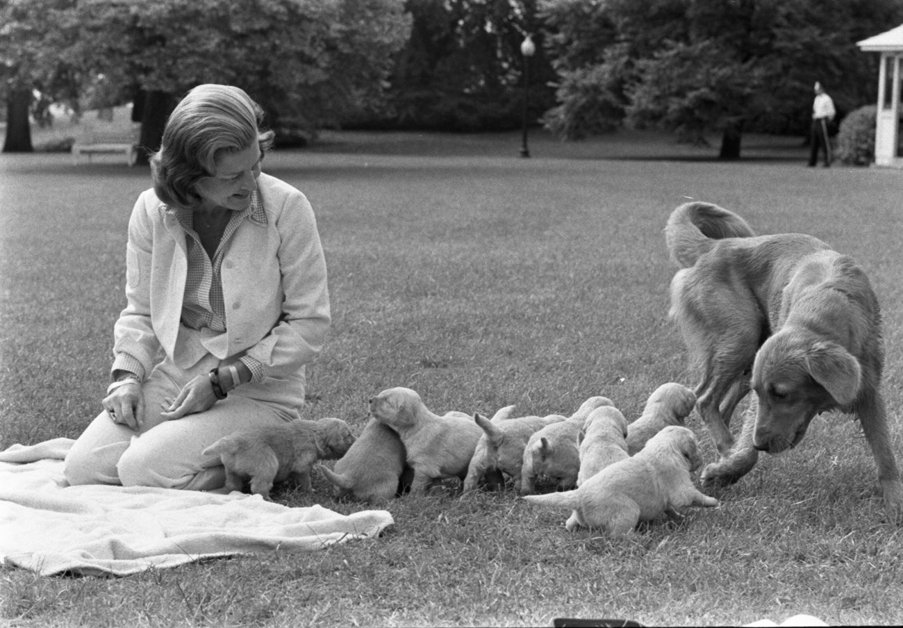 Betty Ford on the White House lawn with her dog Liberty and puppies.