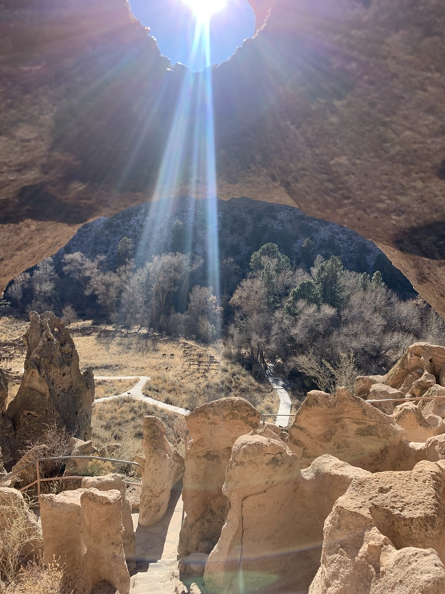 view out of caveate door overlooking stone structure below.