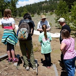 Volunteer talking to visitors at Excavation Site