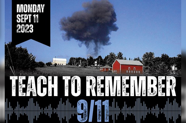 Red barn with smoke plume rising above the hillside on the morning of September 11, 2001.