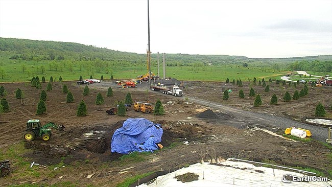 View of construction site with crane placing large concrete uprights for the future Tower of Voices