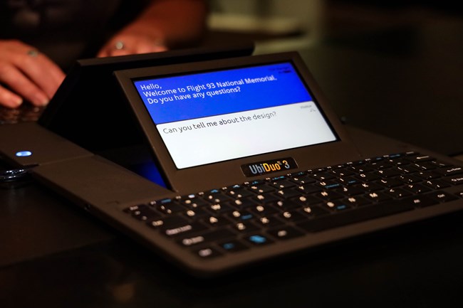 A device (Ubi-Duo) with a keyboard and display showing questions and conversation.