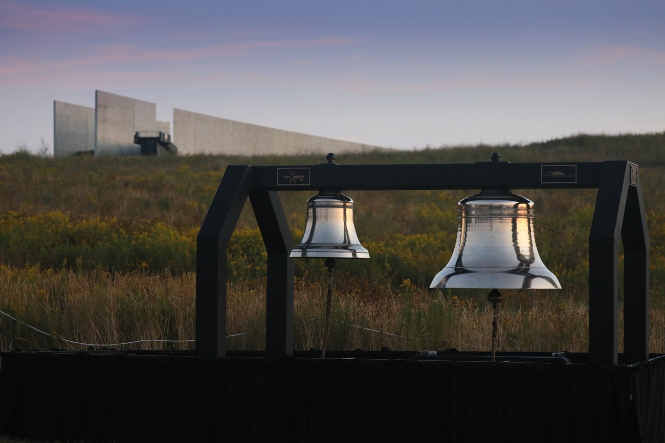 The ceremonial Bells of Remembrance with visitor center in the background.