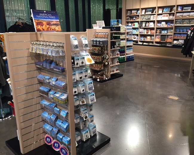 View of books on wooden shelves, patches, pins and other retail items.