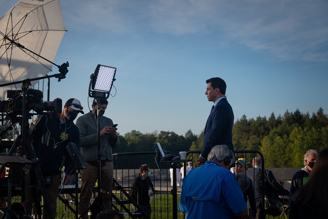 A camera crew with a man standing in front of the camera.
