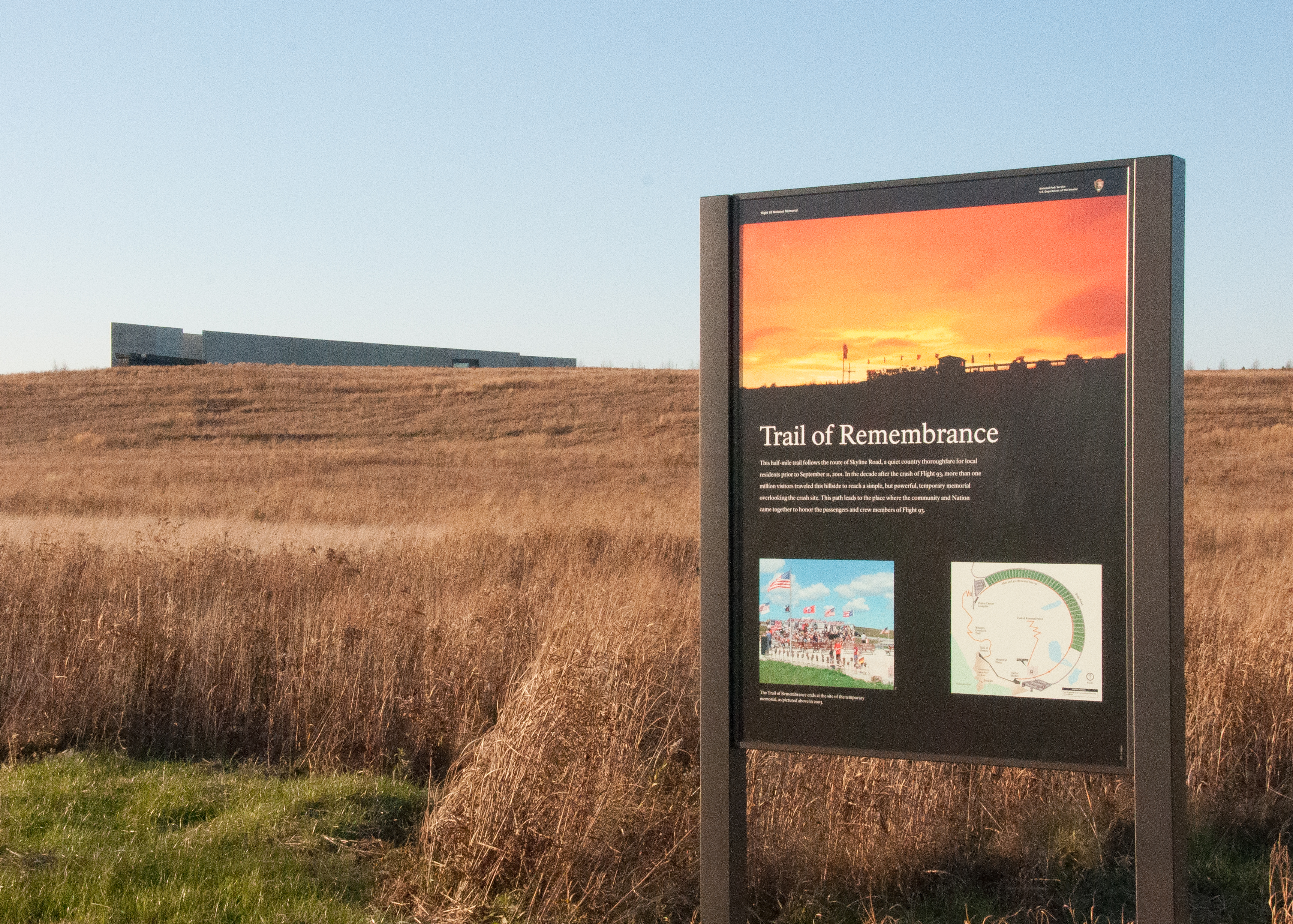 Sign in foreground with field and building in background