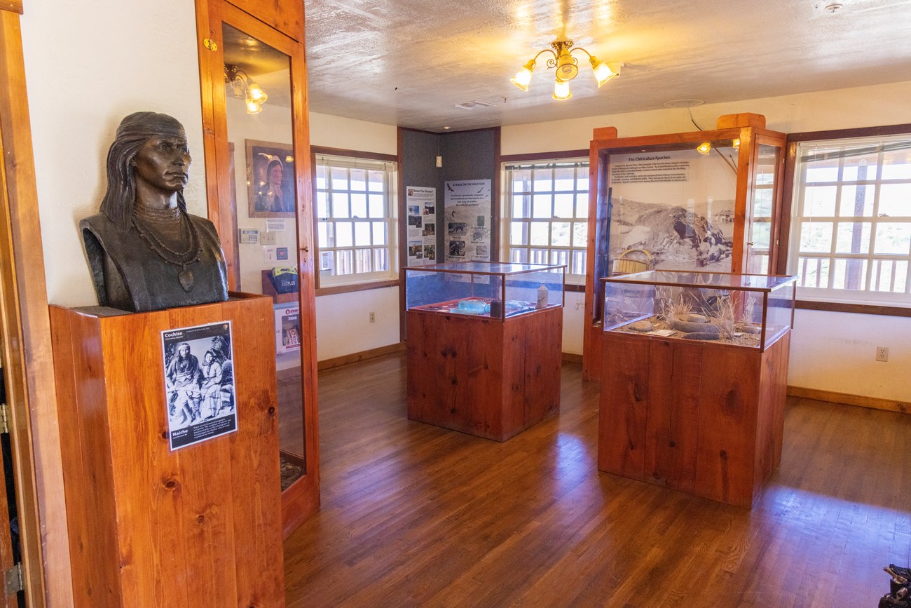 interior view of visitor center with wood and glass display cases containing artifacts from the site
