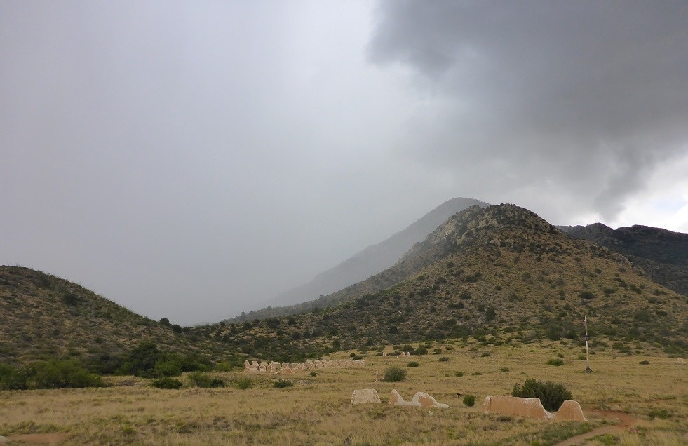 Heavy rain clouds come over the mountain and the ruins at Fort Bowie.