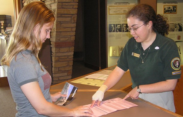 volunteer providing information to visitor at front desk volunteer providing information to visitor at front desk