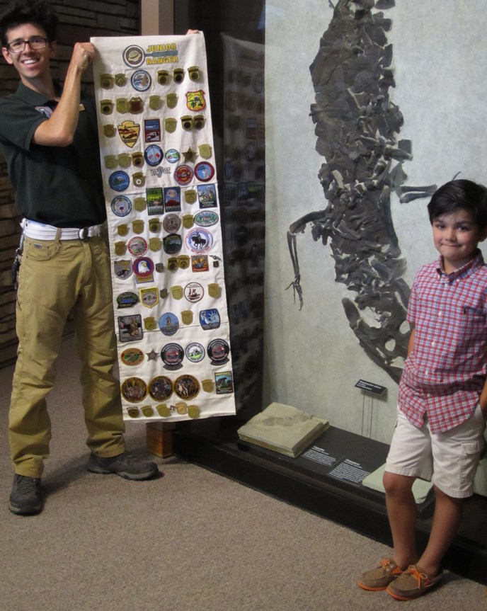 Matthew, age 7, a proud Jr. Ranger of several NPS sites stands with Andy, a GeoCorps Intern Matthew, age 7, a proud Jr. Ranger of several NPS sites stands with Andy, a GeoCorps Intern