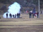 Picture of a volunteers in period dress firing the post cannon during flag lowering ceremony.