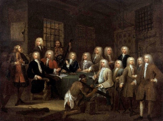 A group of men in 18th century garb around a table.