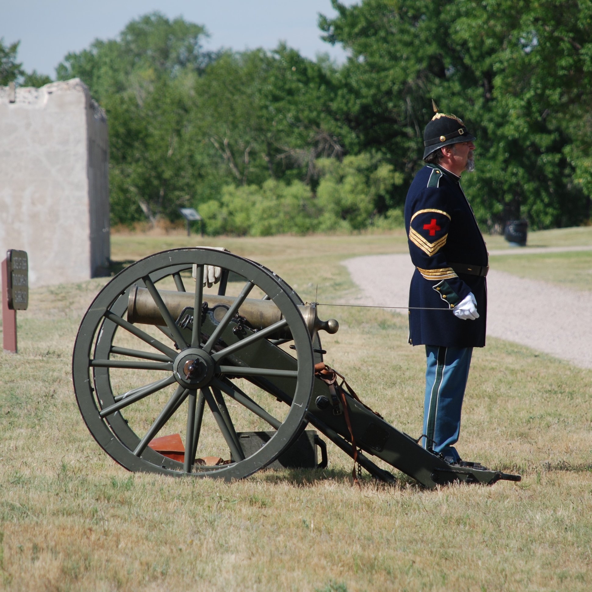 Ranger Joe about to fire the cannon during a past 4th of July. Ranger Joe in a 19th century hospital steward uniform next to a cannon.