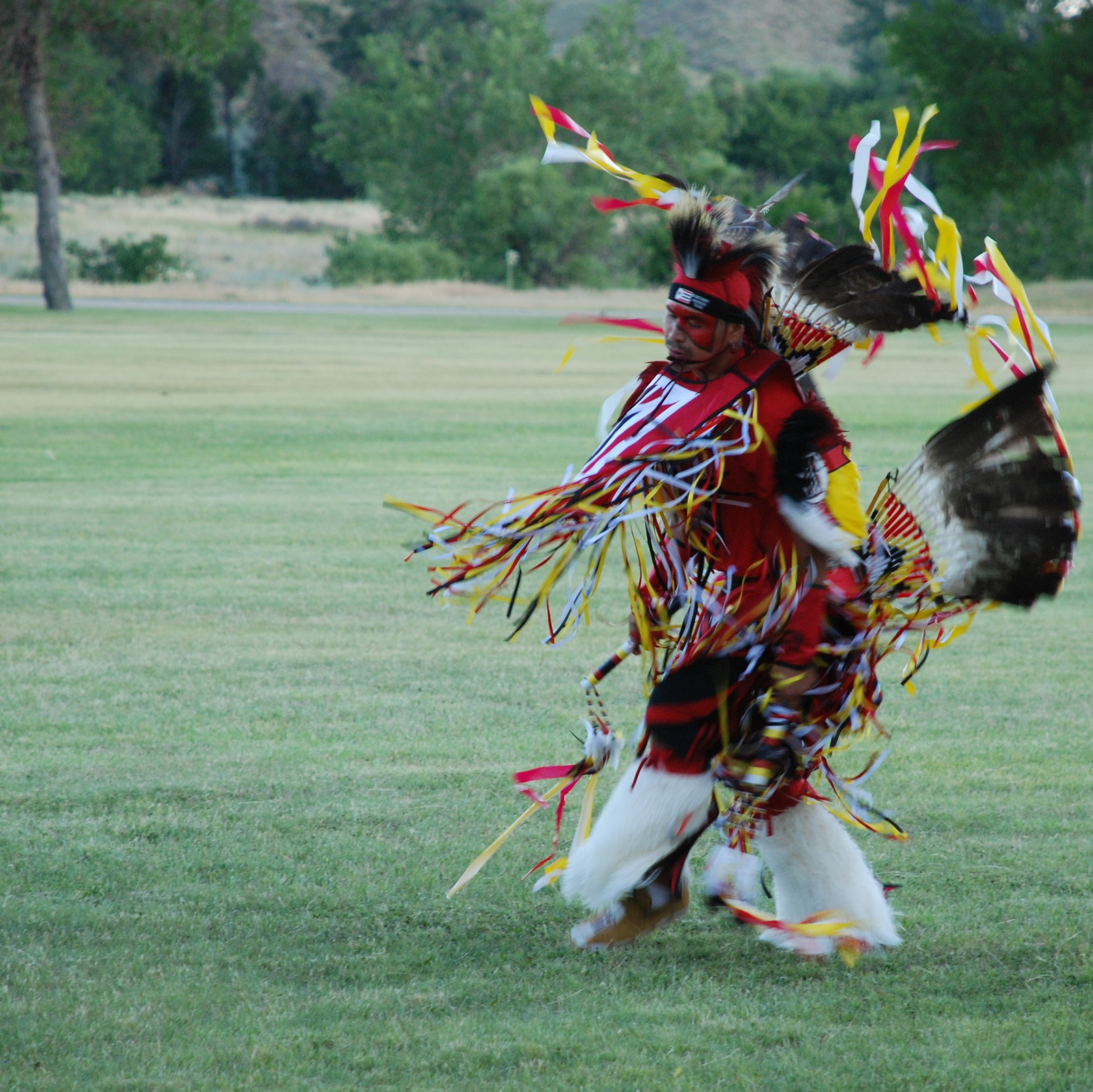 A man in a fancy dance costume dancing at Fort Laramie.