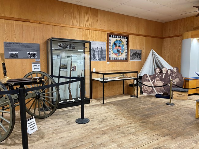 Exhibit cases, historic firearms, and historic figure cutouts on display