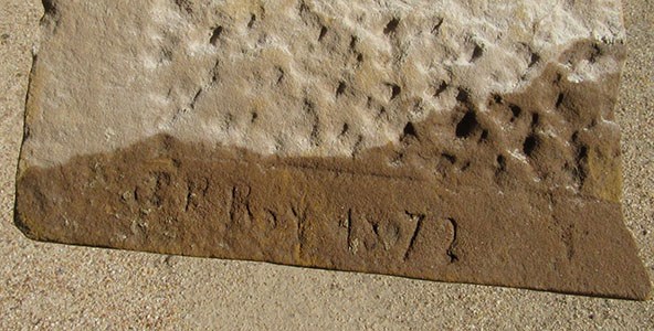 Piece of sandstone brick with "Roy P Head" carved on it.