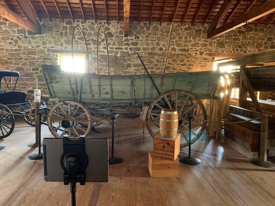 Distance Learning Set Up Connestoga wagon inside a sandstone brick building with iPad set up for program in front of it.
