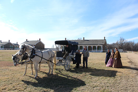 Horse-drawn carriage with people waiting to get a ride.