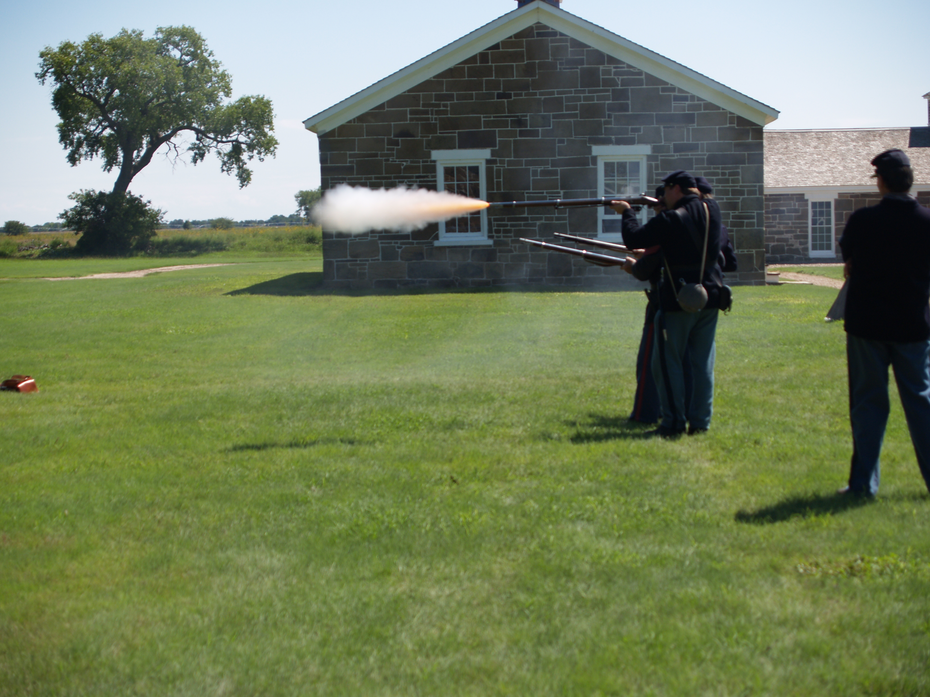 Small arms demonstration Re-enactors standing in a line firing historic weapons.