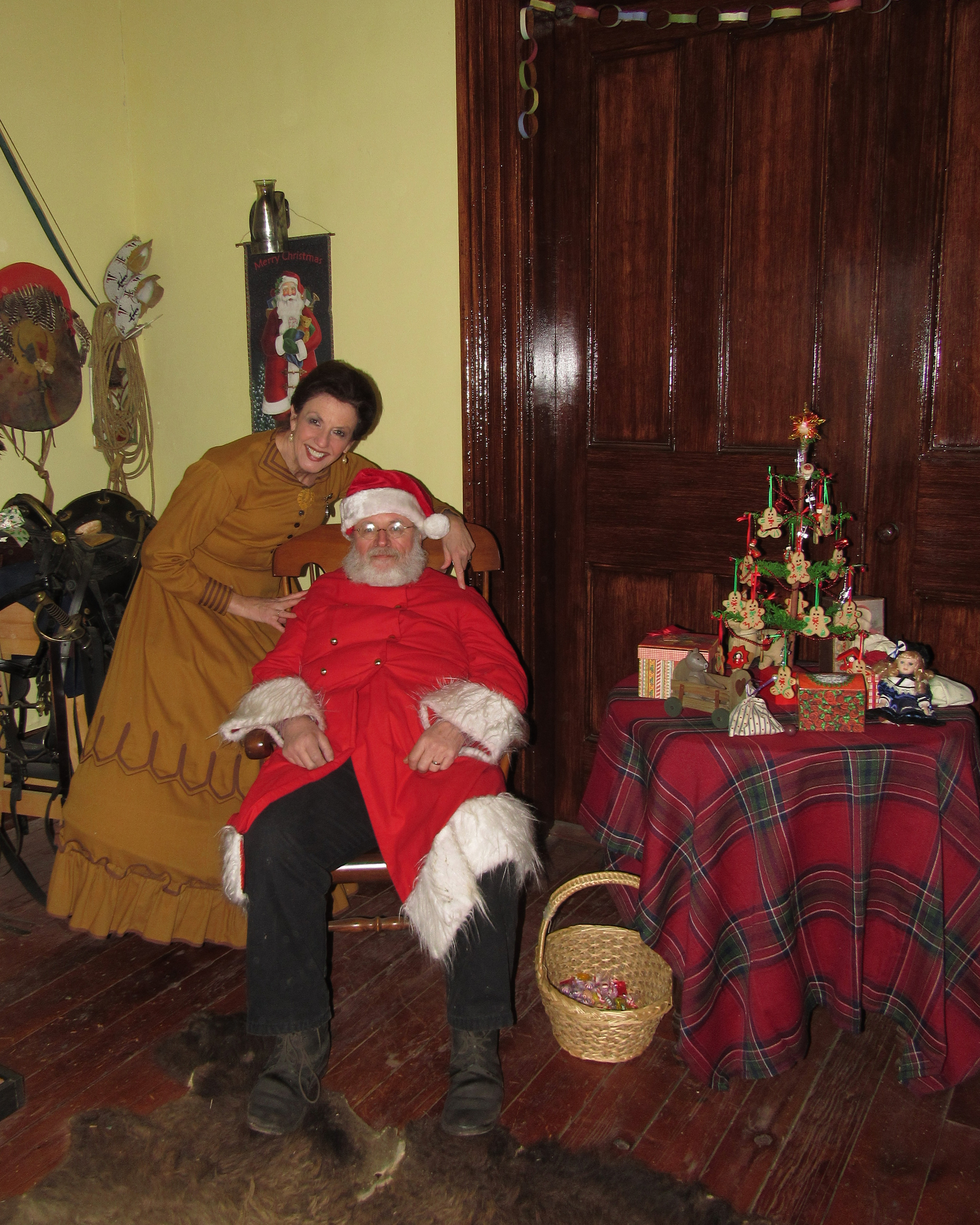 Posing with Santa Claus A woman in a hoop skirt poses next to Santa Claus in a room with mid-19th century furniture.