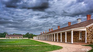 Two sandstone buildings beneath a cloudy sky.
