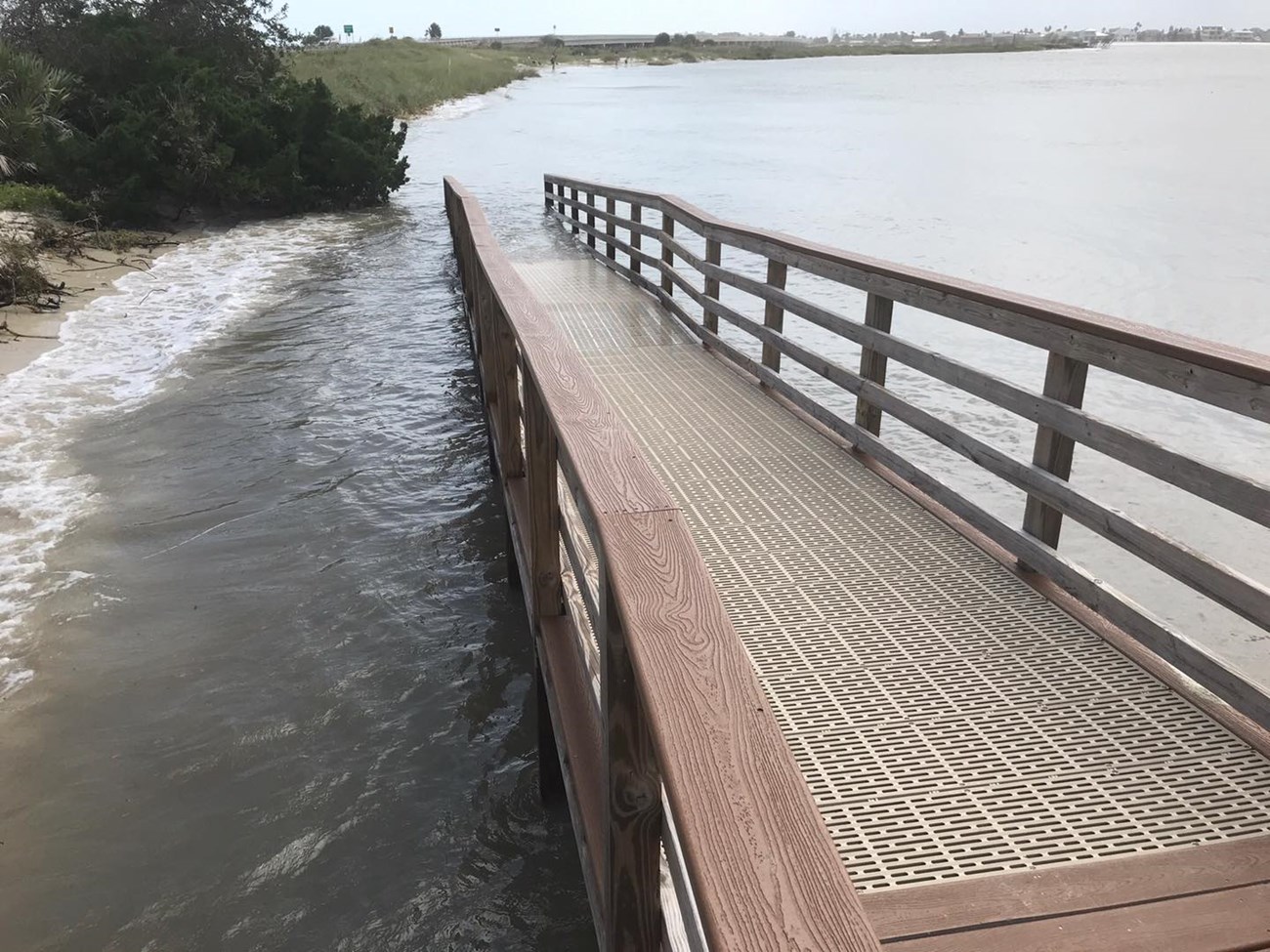A view of the river boardwalk under water from high tide.