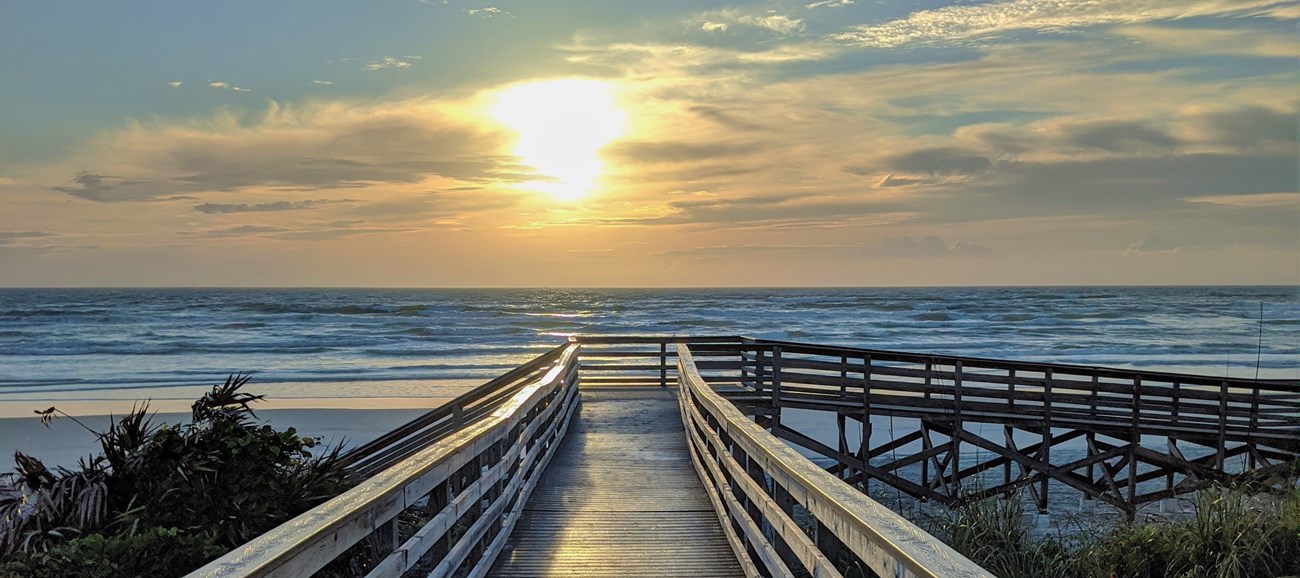 Sunrise over the oceanside boardwalk.